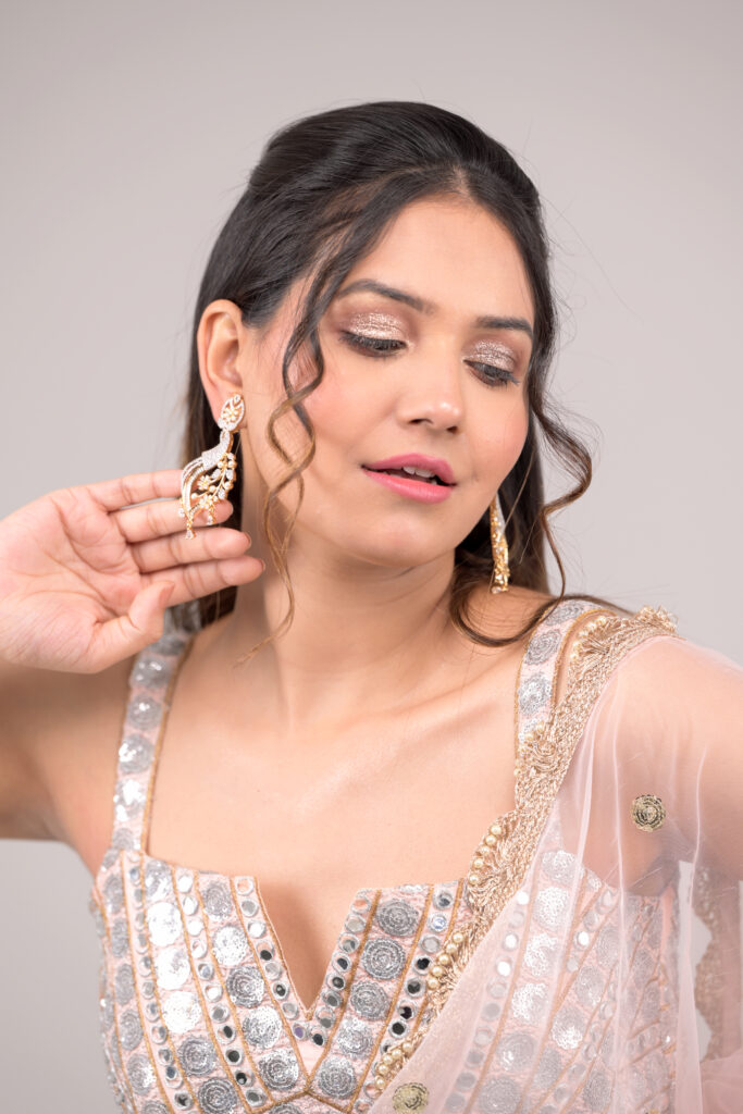 Dual-tone gold and rhodium plated peacock-inspired earrings featuring pavé cubic zirconia, glass pearls, and teardrop-shaped stones.